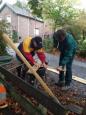 Werk in uitvoering; planken op maat zagen voor de reparatie van de beschoeiing